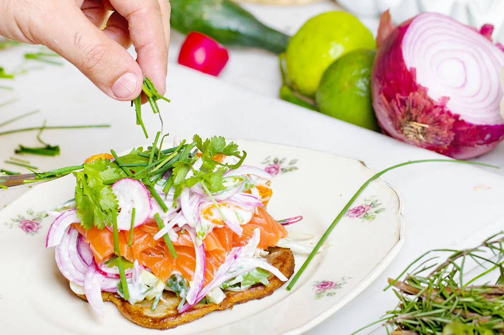 Tostada de pan integral con salmón ahumado, cebolla, miel y cilantro