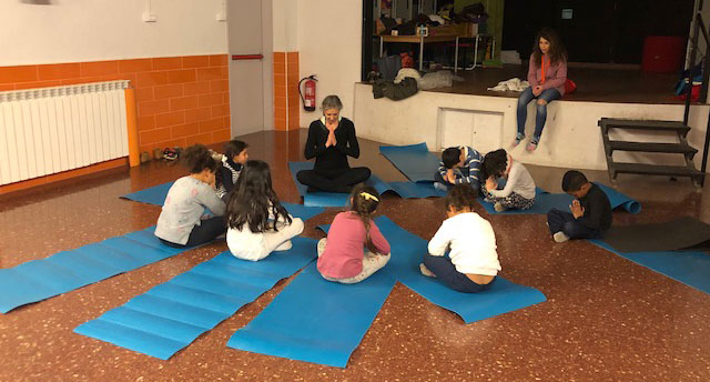 niños y niñas meditando en el taller de la fundació dir yoga for all